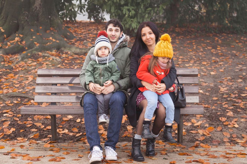 Photo de famille assise sur un banc lors d'un shooting automnal.