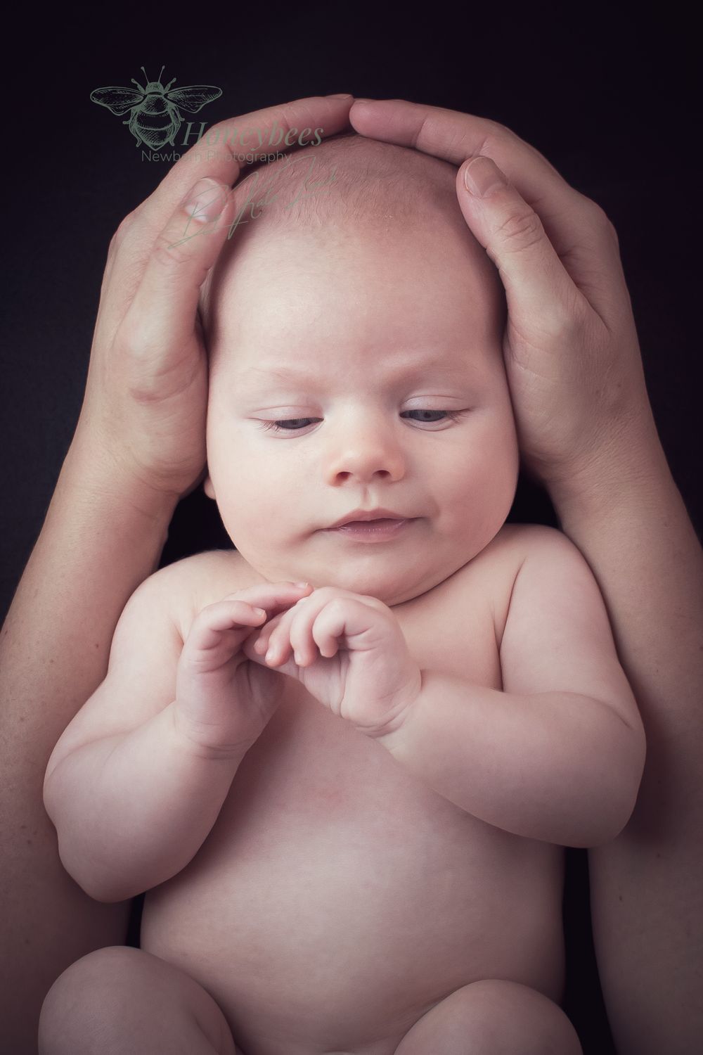 3 week old new born baby being held with not clothes on. mums arms are wrapped around baby body lovingly holding is head