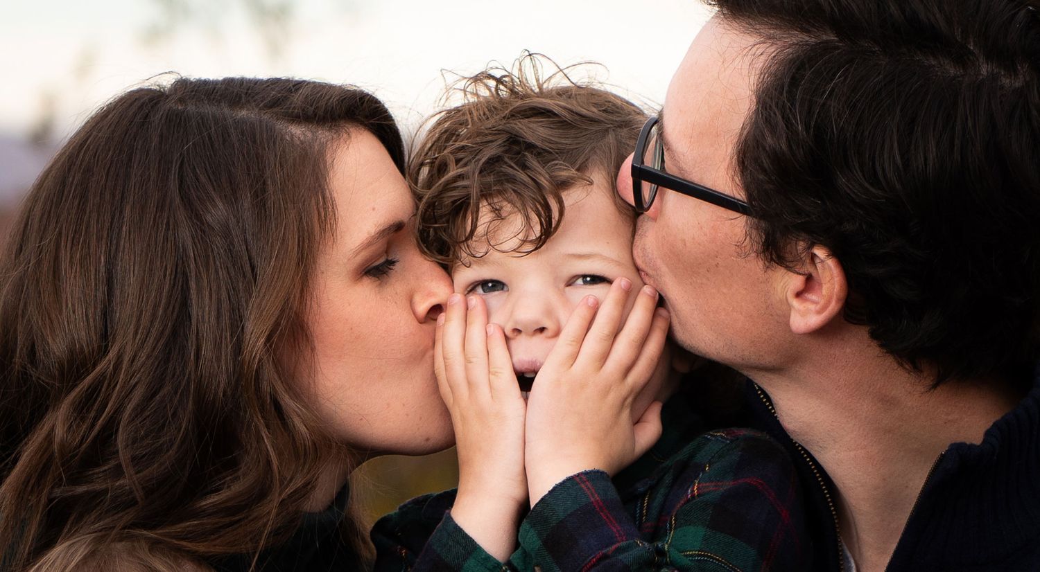 margie-temme-takes-family-portrait-with-mom-and-dad-kissing-young-son