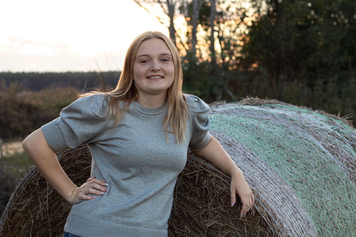 Senior girl by a hay bale