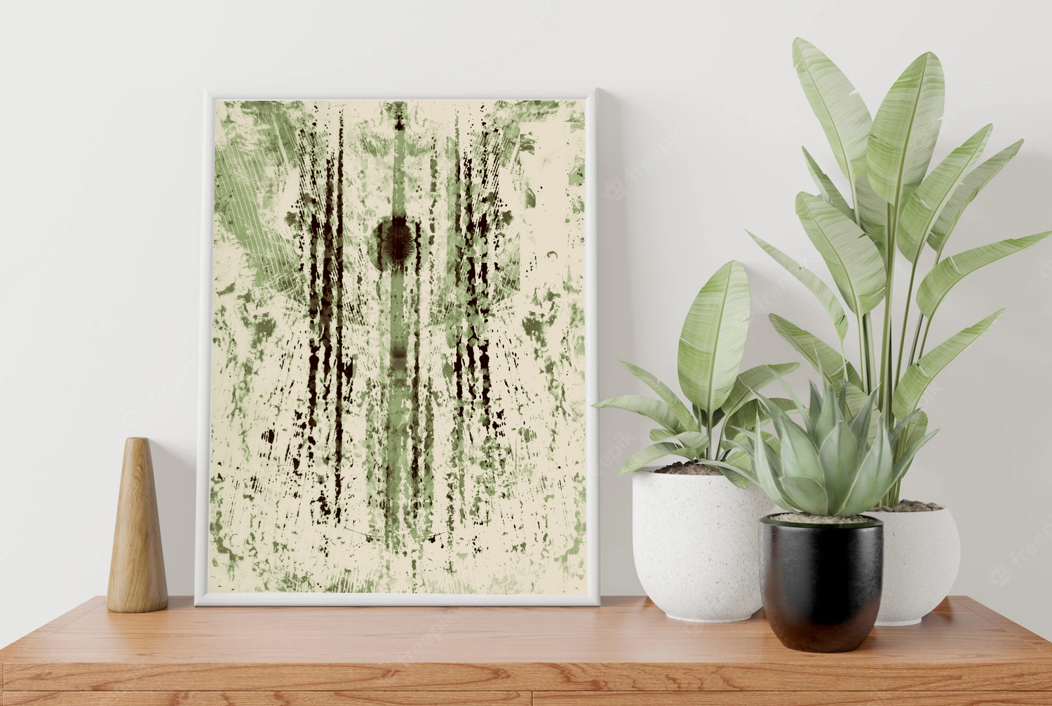 Modern wall art with green abstract design displayed alongside potted plants on wooden furniture.