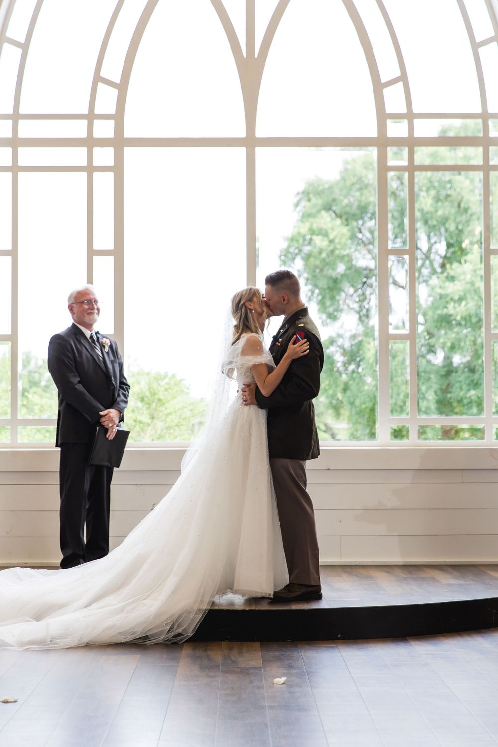 Wedding ceremony under an elegant arched window with beautiful natural light streaming in.