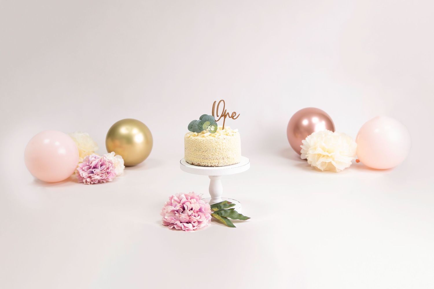 1 year cake smash, cream, pink and gold & rose gold balloons, cream/ pink flowers & tissue pom poms, beige backdrop