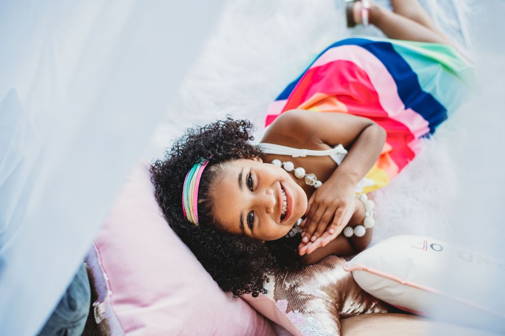 Whimsical outdoor photography session featuring a white tent and colorful props.