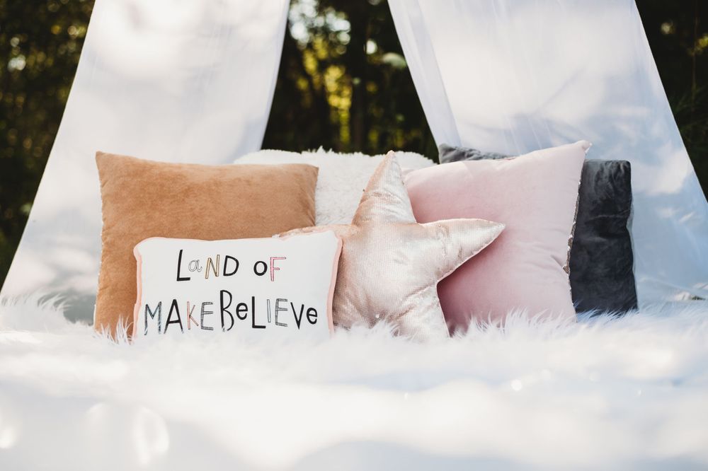 White cushions and pillows arranged inside a teepee tent for outdoor photography.