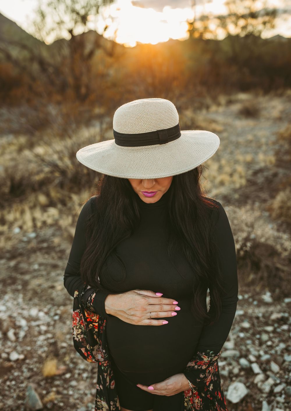 a pov photo of a women from above holding her belly at a maternity session