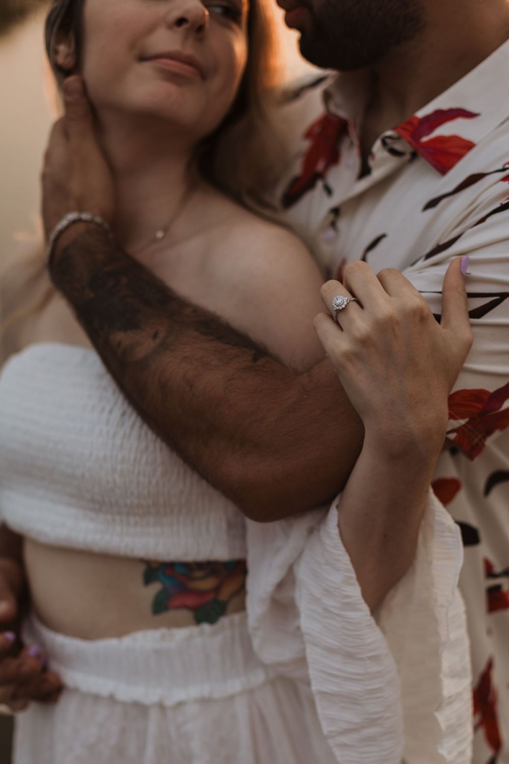 Intimate close up portrait showing engagement ring and floral pattern shirt details.