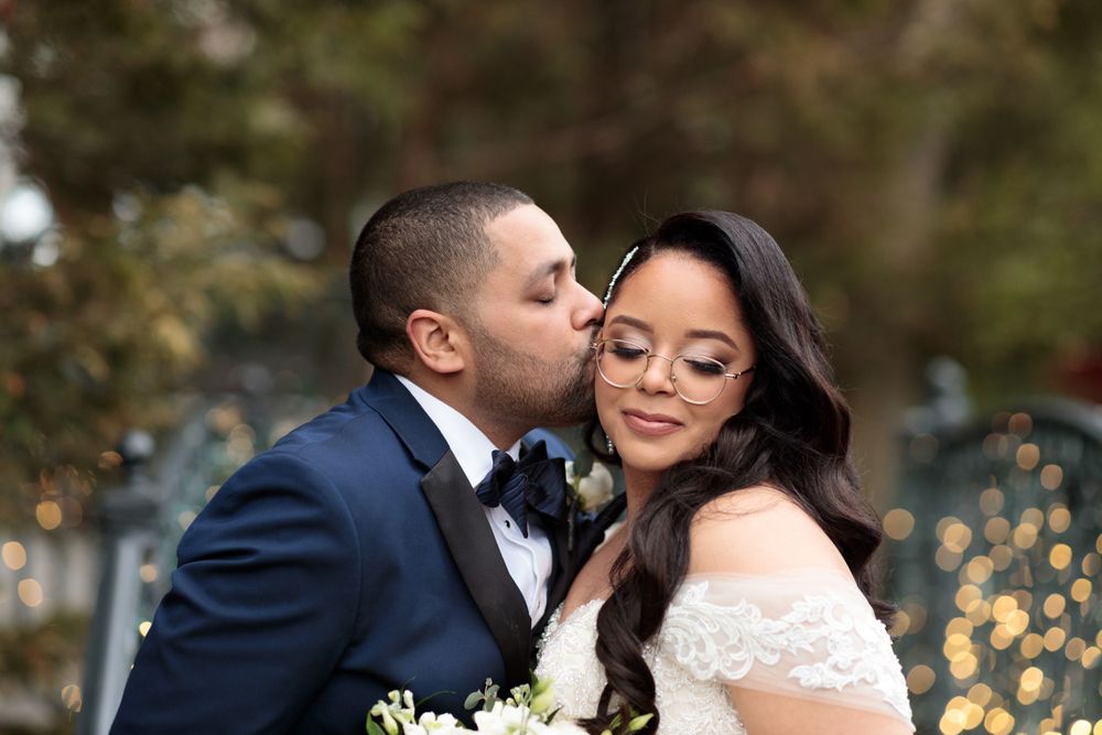 Intimate wedding portrait with soft lighting and sparkles in background.