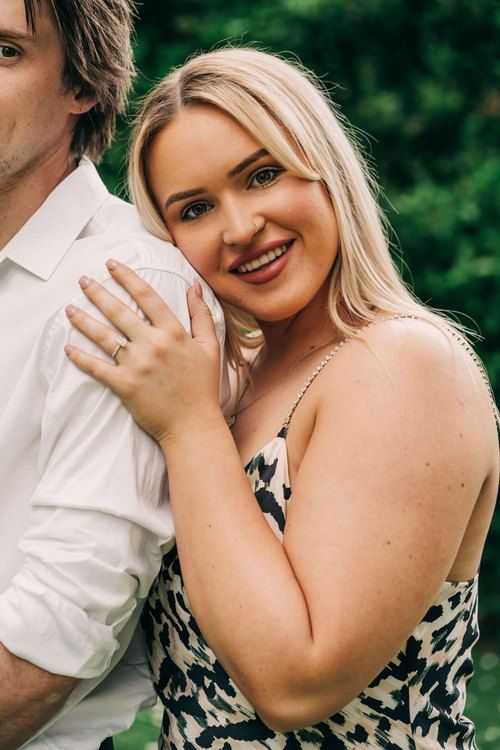 Close-up portrait in natural outdoor setting with floral dress and white shirt.