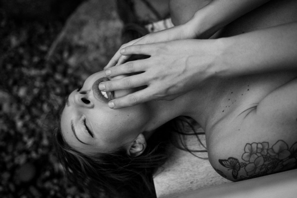 Dramatic black and white portrait showing emotion and body art.
