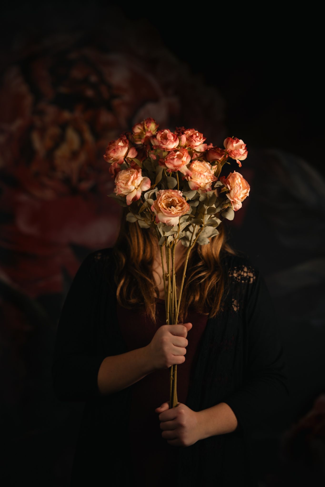 Dramatic lighting illuminates orange roses held against dark background in sequential shots.