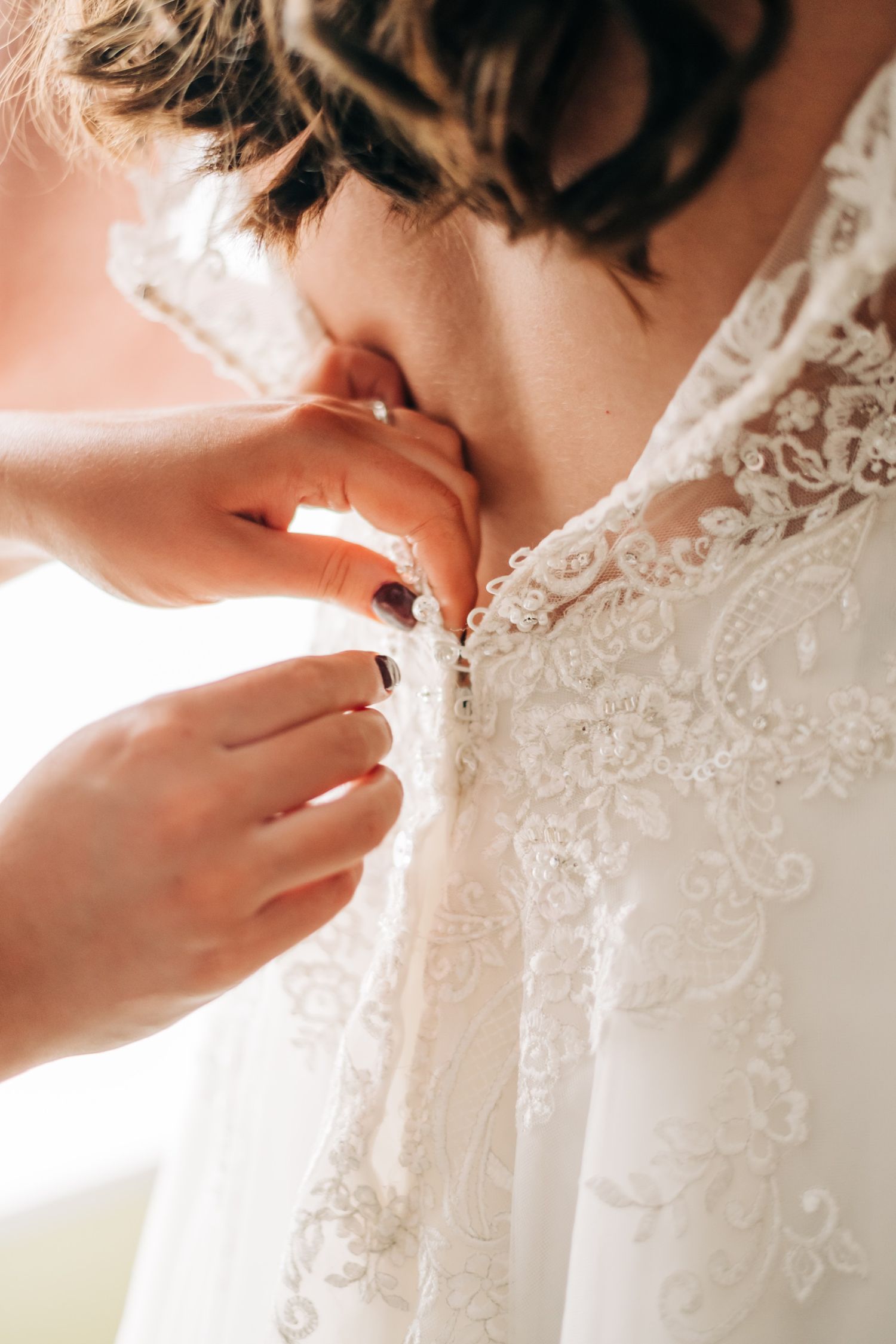 close up photo of buttons on bride's wedding dress