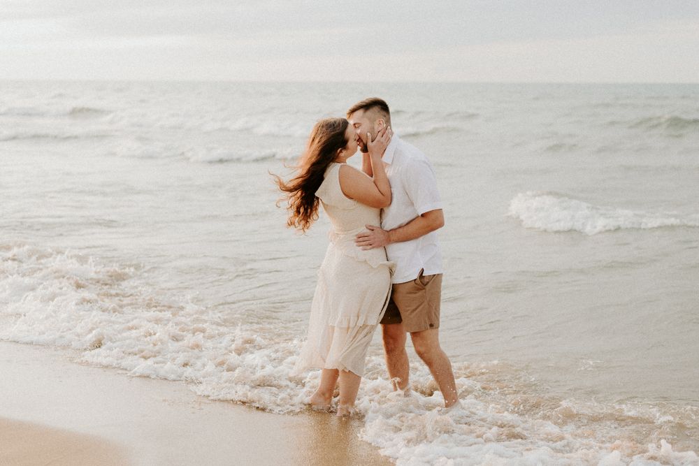 Couple enjoying romantic moment together on beach with waves in background.