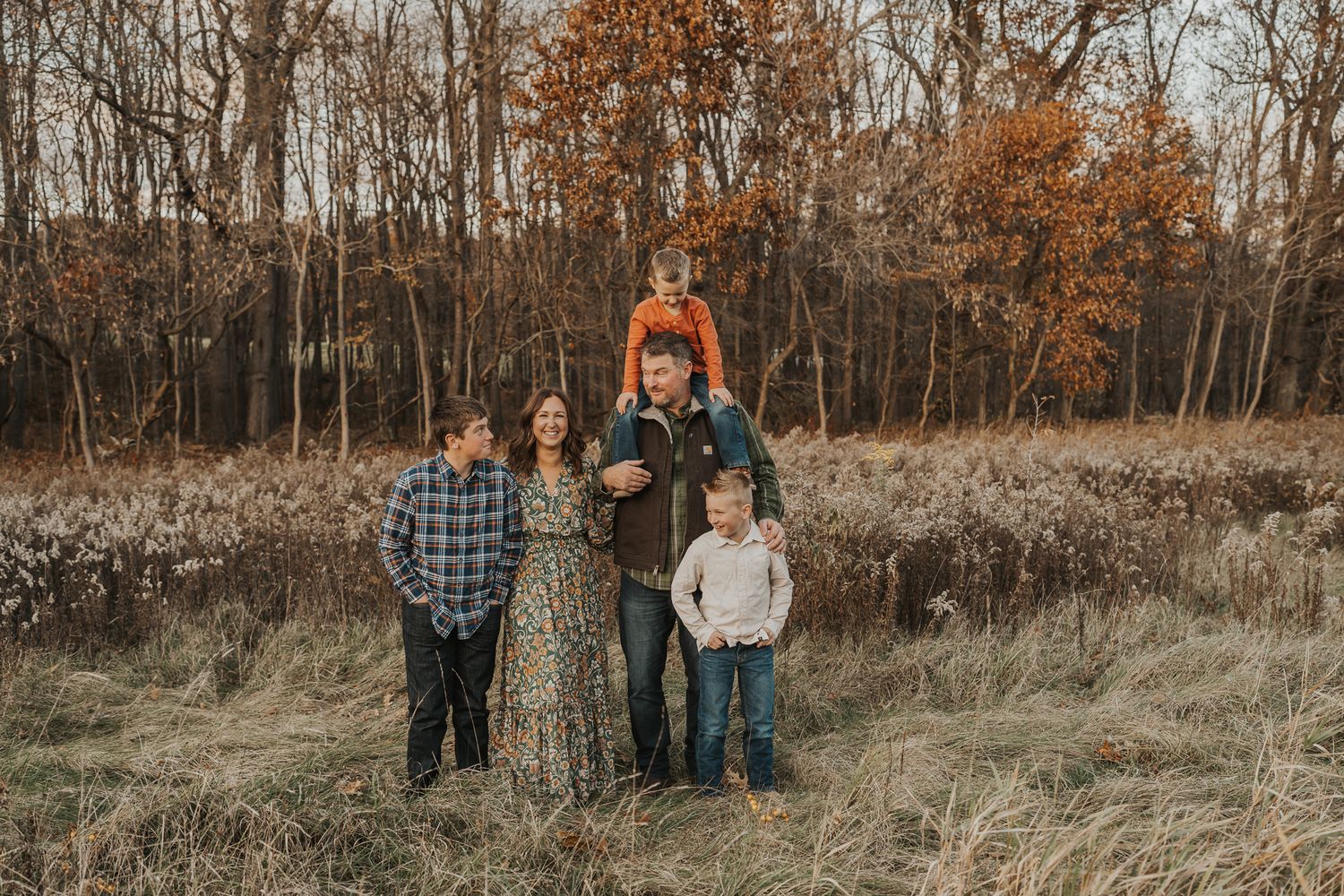 Group of people standing in a line against an autumn forest backdrop.