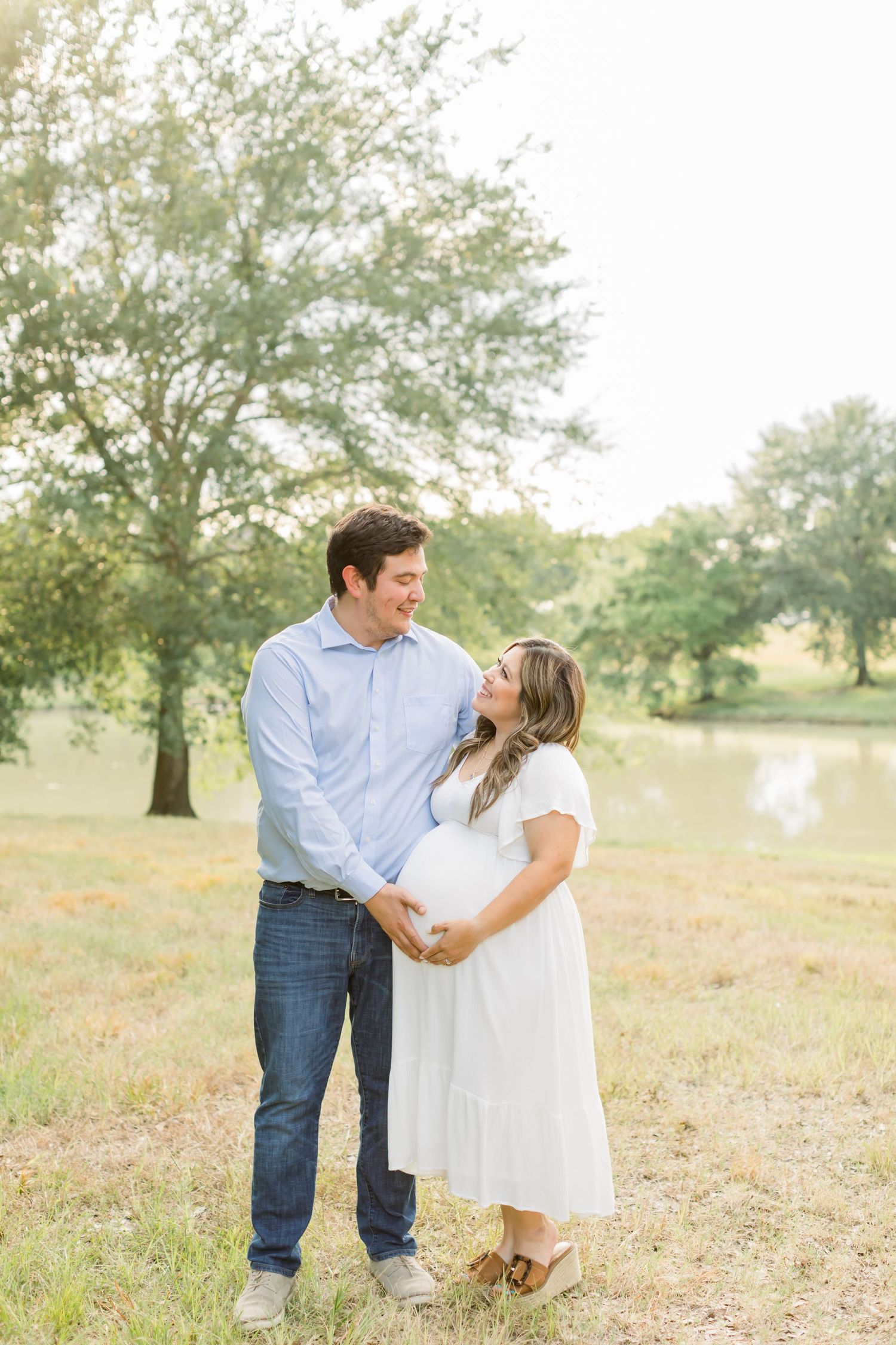 A romantic couple shares an affectionate moment outdoors in a serene natural setting.