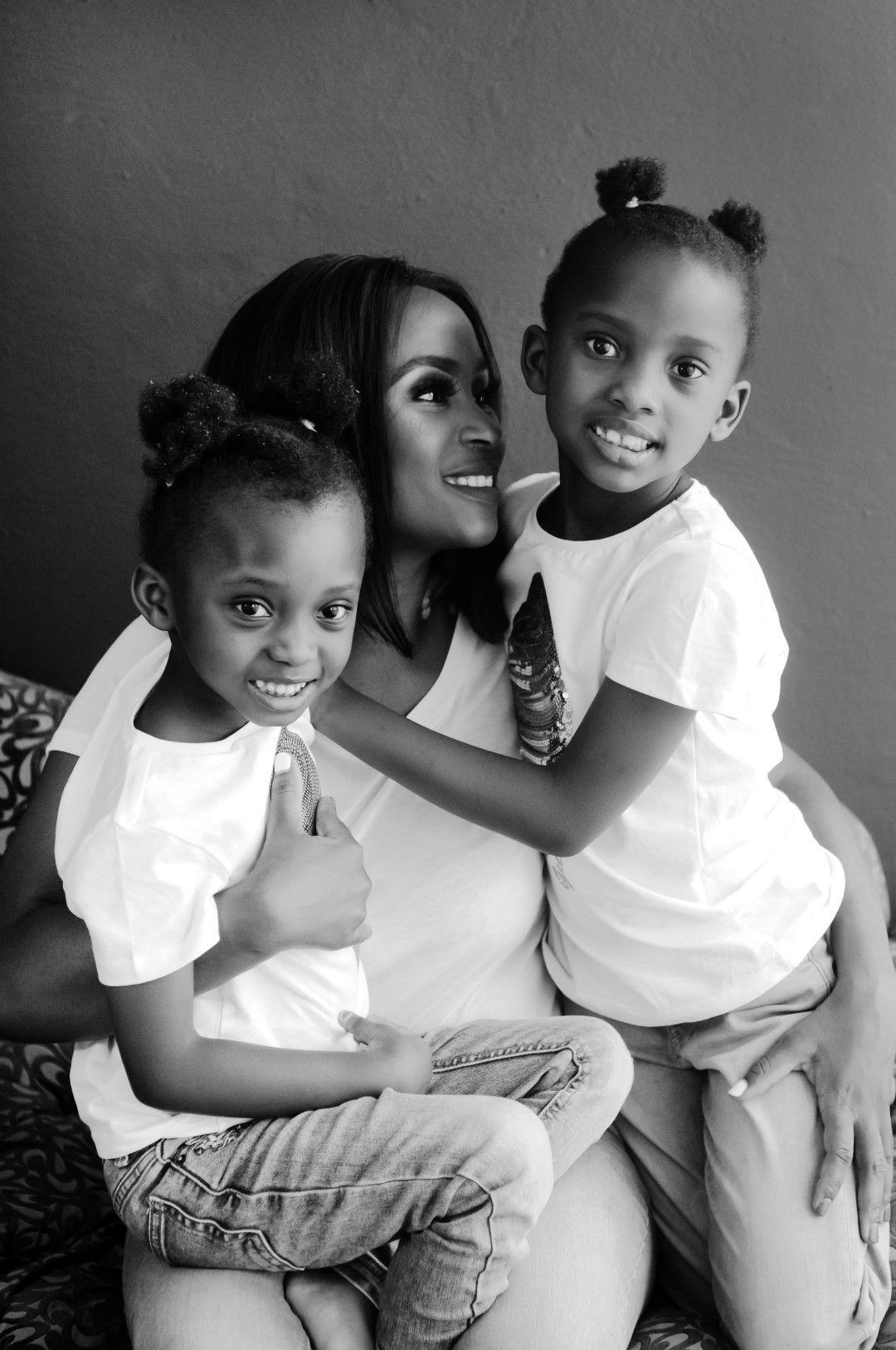 Beautiful mom and daughters posing together in photo studio in Helderkruin