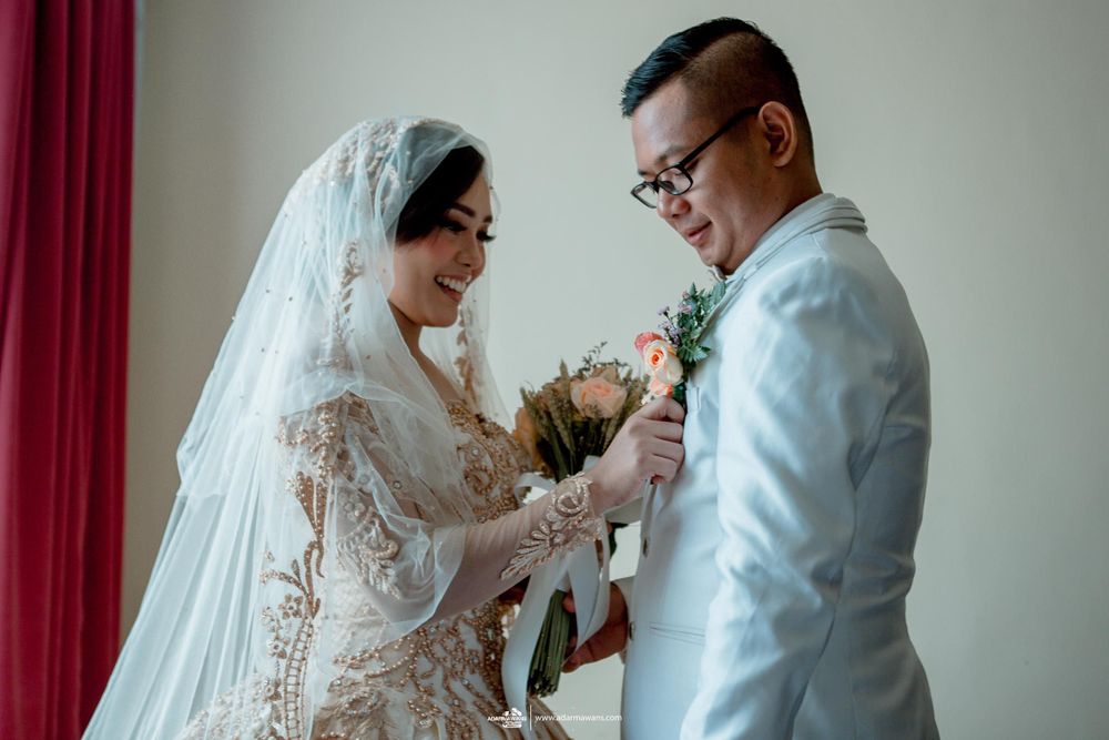 Intimate moment between couple in wedding attire exchanging flowers.