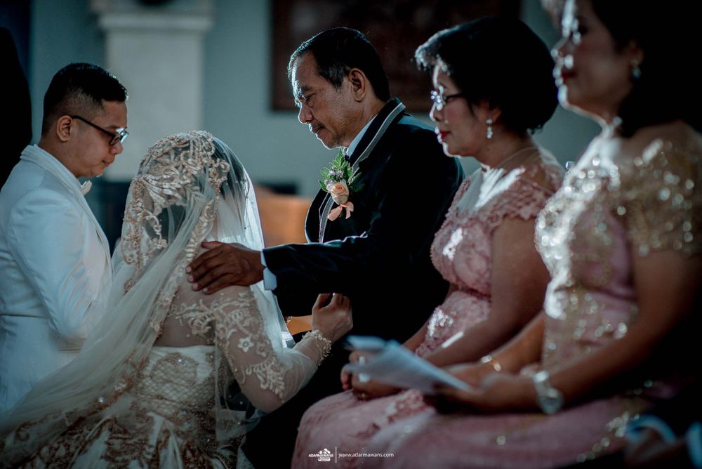 Attendees in formal attire participate in a traditional wedding ceremony ritual.