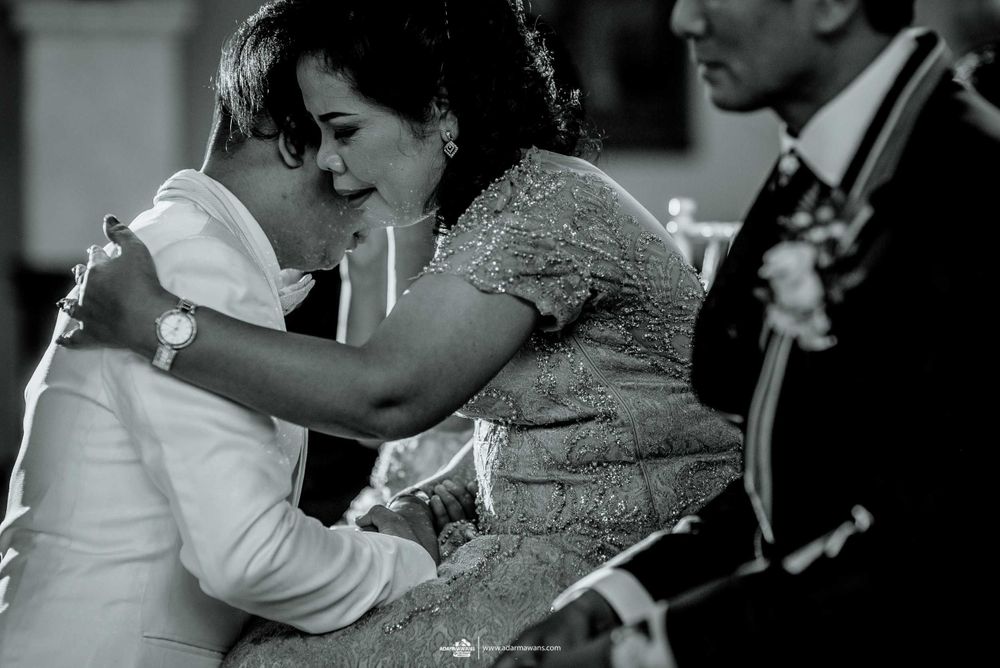 An intimate black and white moment of embrace during a wedding celebration.