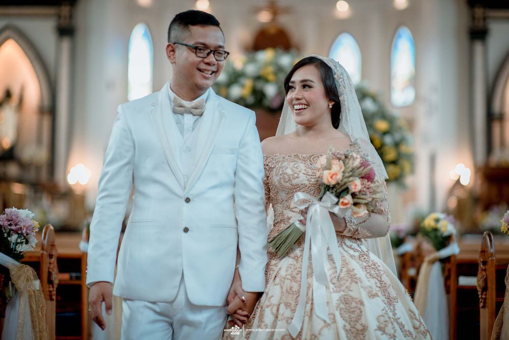 A wedding ceremony inside a beautiful church featuring elegant decorations and stunning stained glass windows.