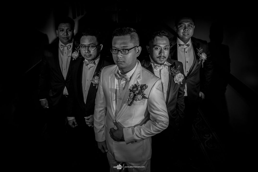 Dramatic black and white shot of wedding party walking in formal attire.