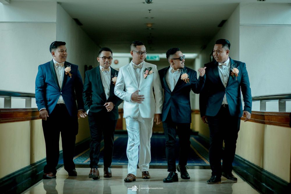 Wedding party walking down a hallway in coordinated blue and white suits.