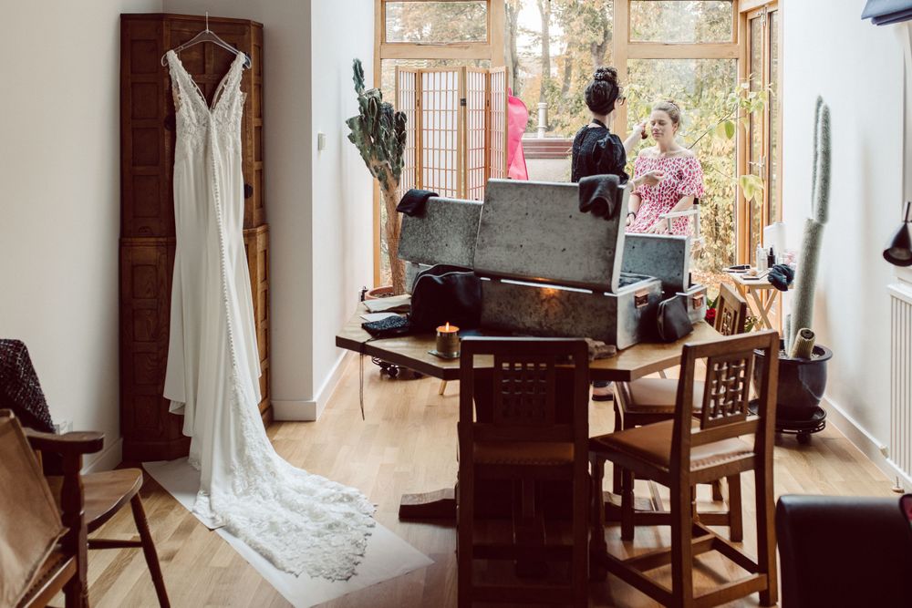 Sunlit bridal preparation room with vintage furniture and flowing curtains.