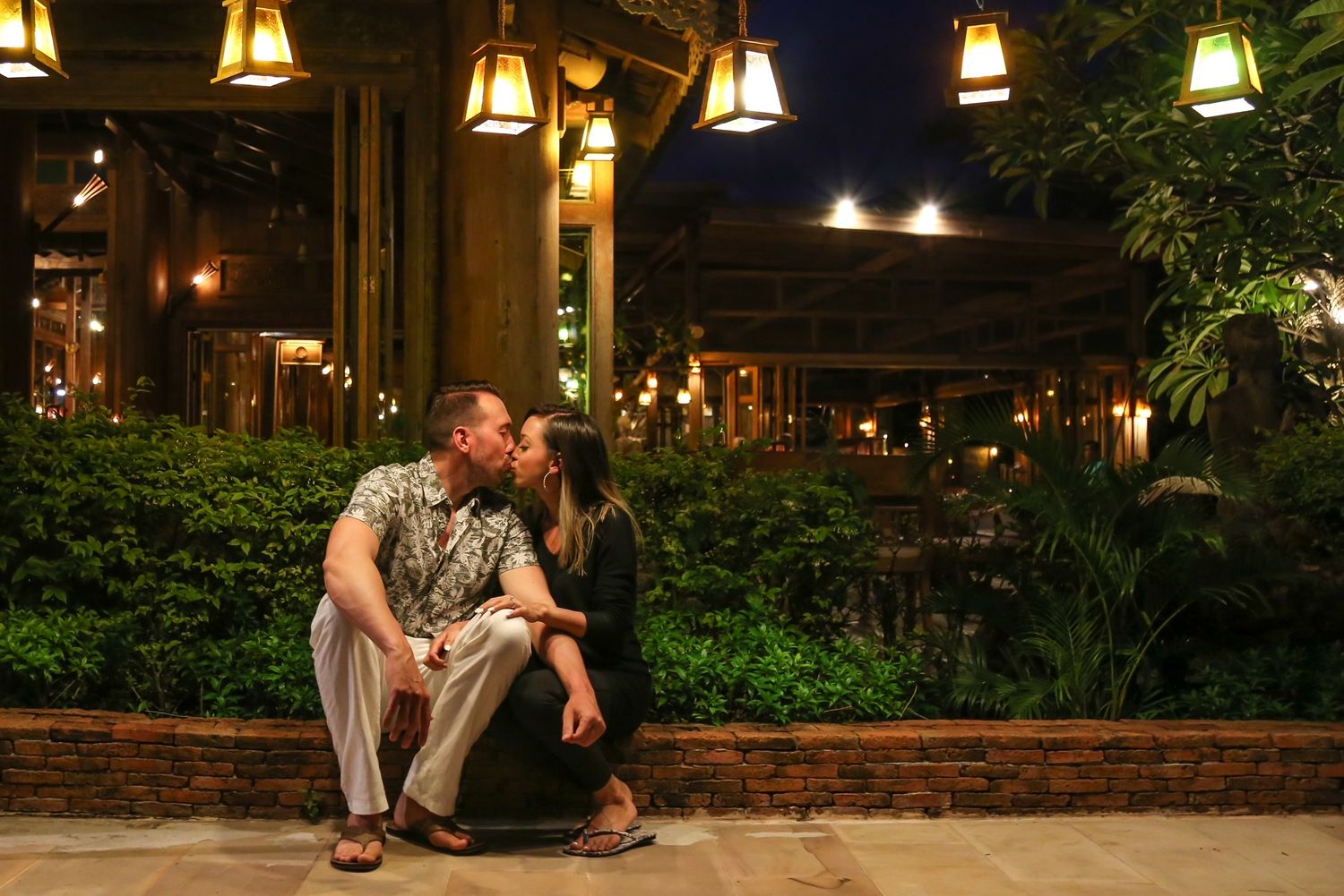white man and asian wife sharing a kiss in Thailand after they got engaged.