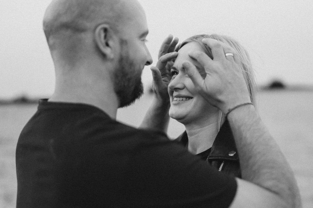 Black and white intimate portrait of couple sharing tender moment outdoors.