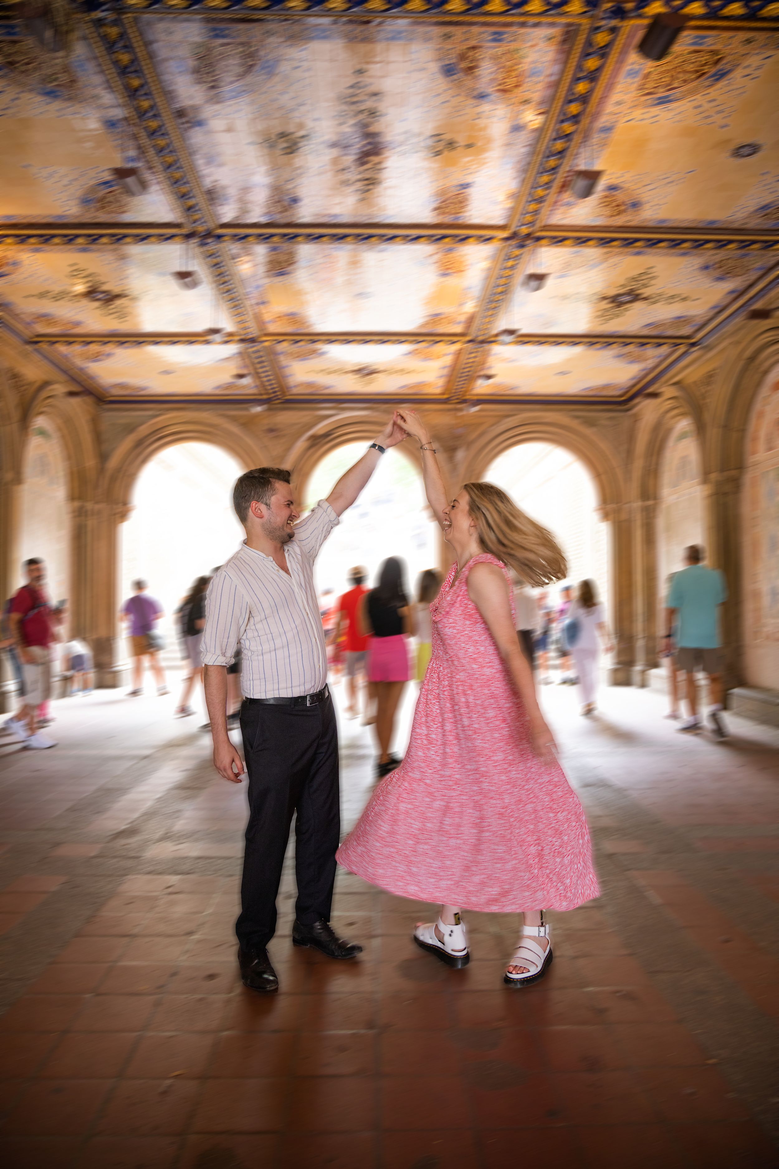 Couple dancing and twirling under ornate painted ceiling at Bethesda Terrace in Central Park, New York City.