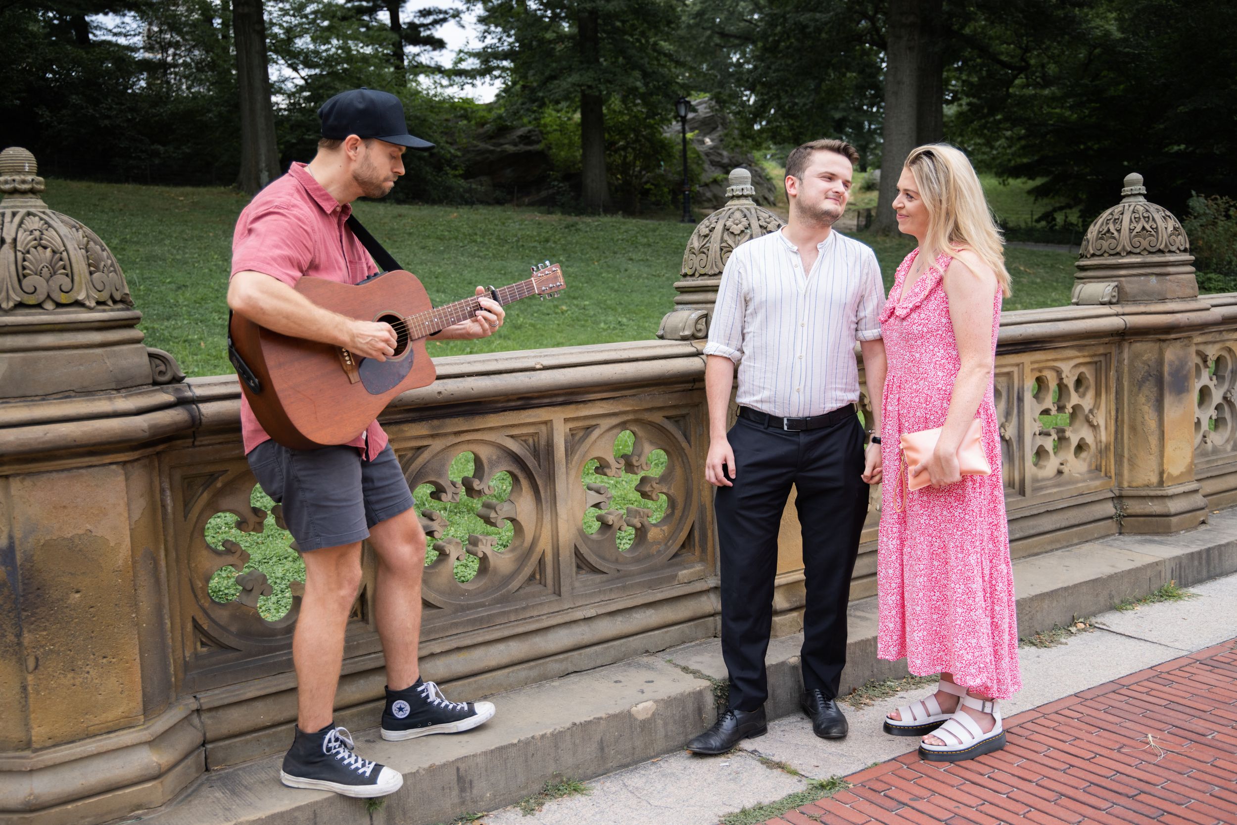 Guitarist serenades couple at Bethesda Terrace in Central Park, NYC.