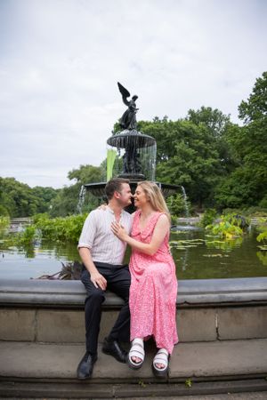 Happy engaged couple shares romantic moment at Bethesda Fountain in Central Park.
