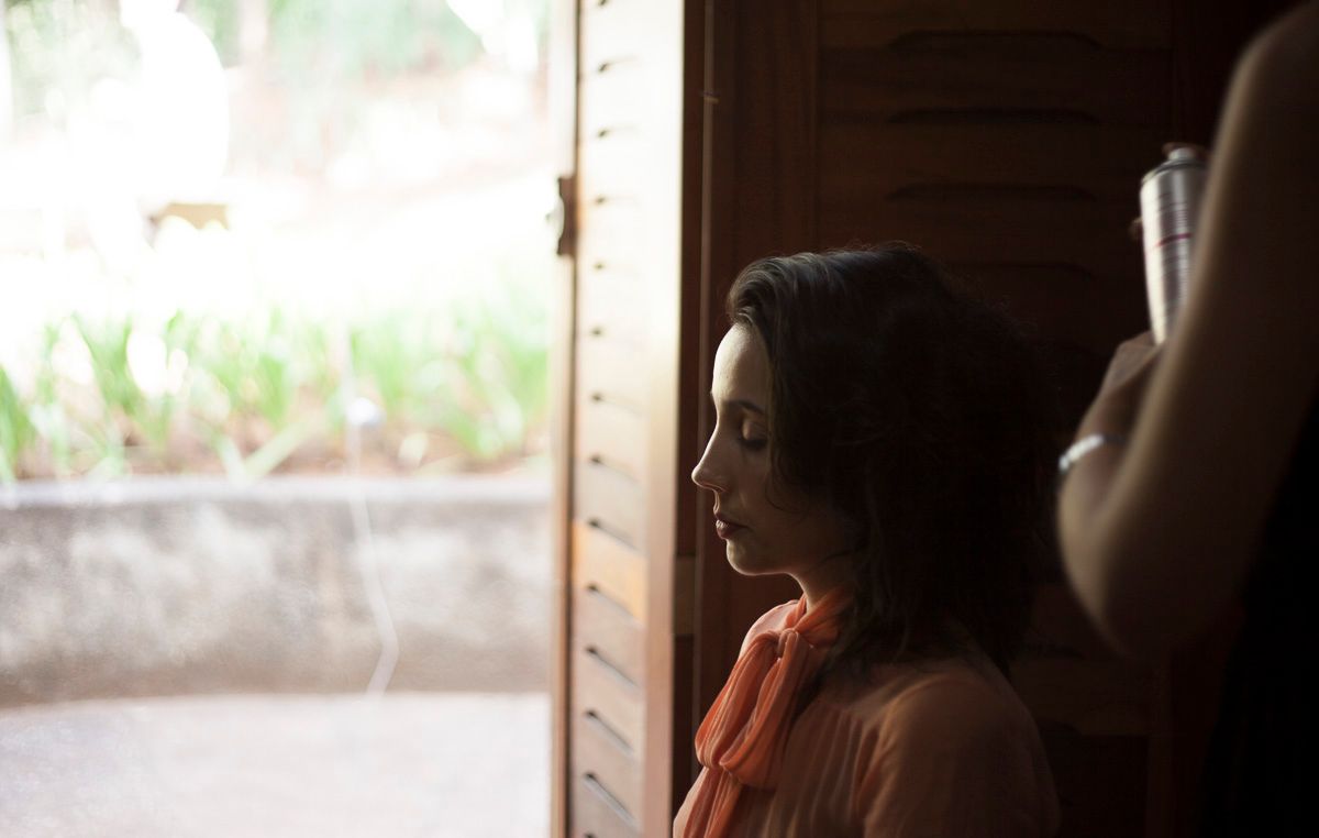 Artistic portrait by a window showing soft natural lighting and contemplative mood.