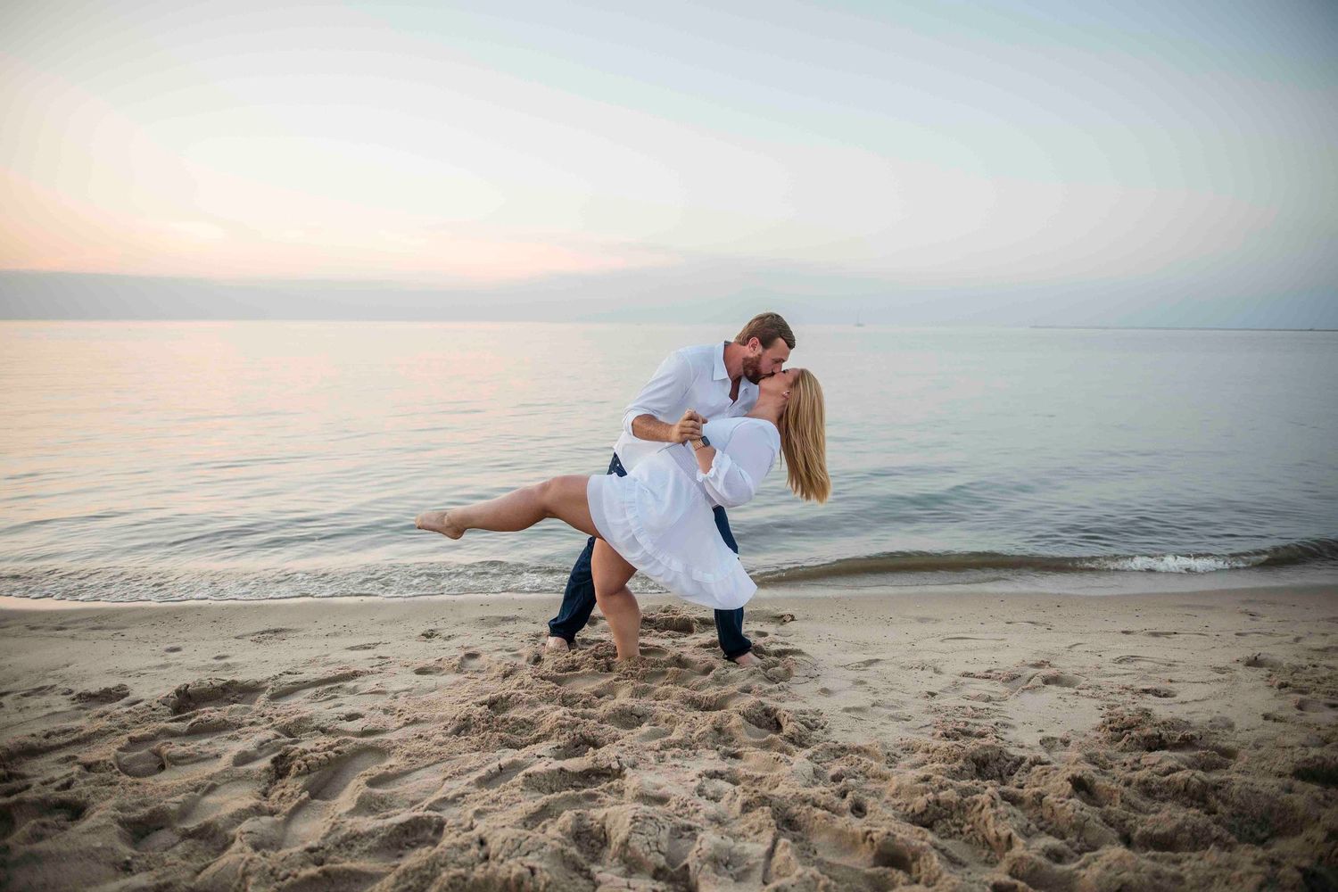Kayla and Zach doing the dip pose at their Beach Engagement at Sunset