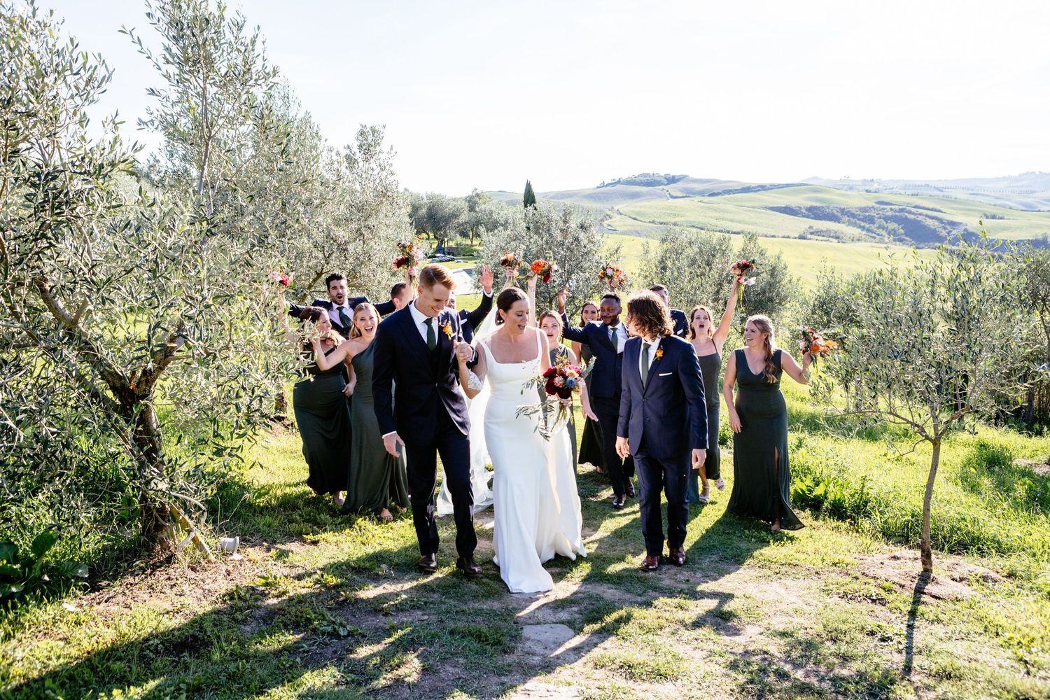 The bridal party walking along a path at The Lazy Olive wedding venue near Siena.