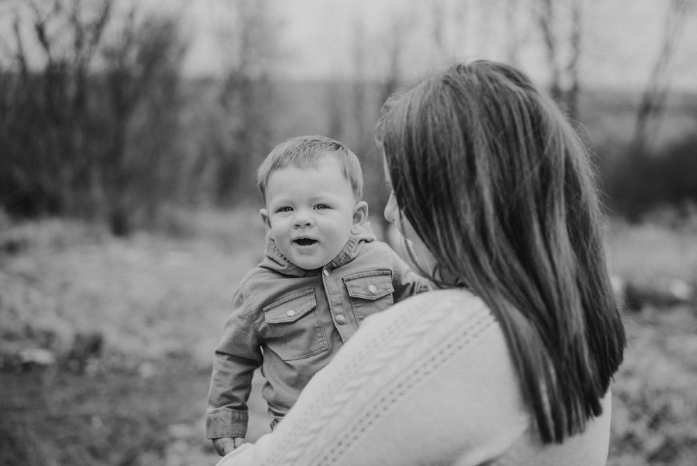 Black and white outdoor family portrait session in natural setting.