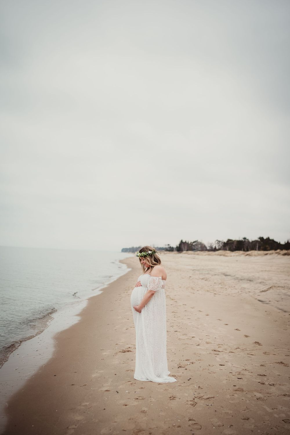 Ethereal beach photography session with footprints in sand and misty oceanfront.
