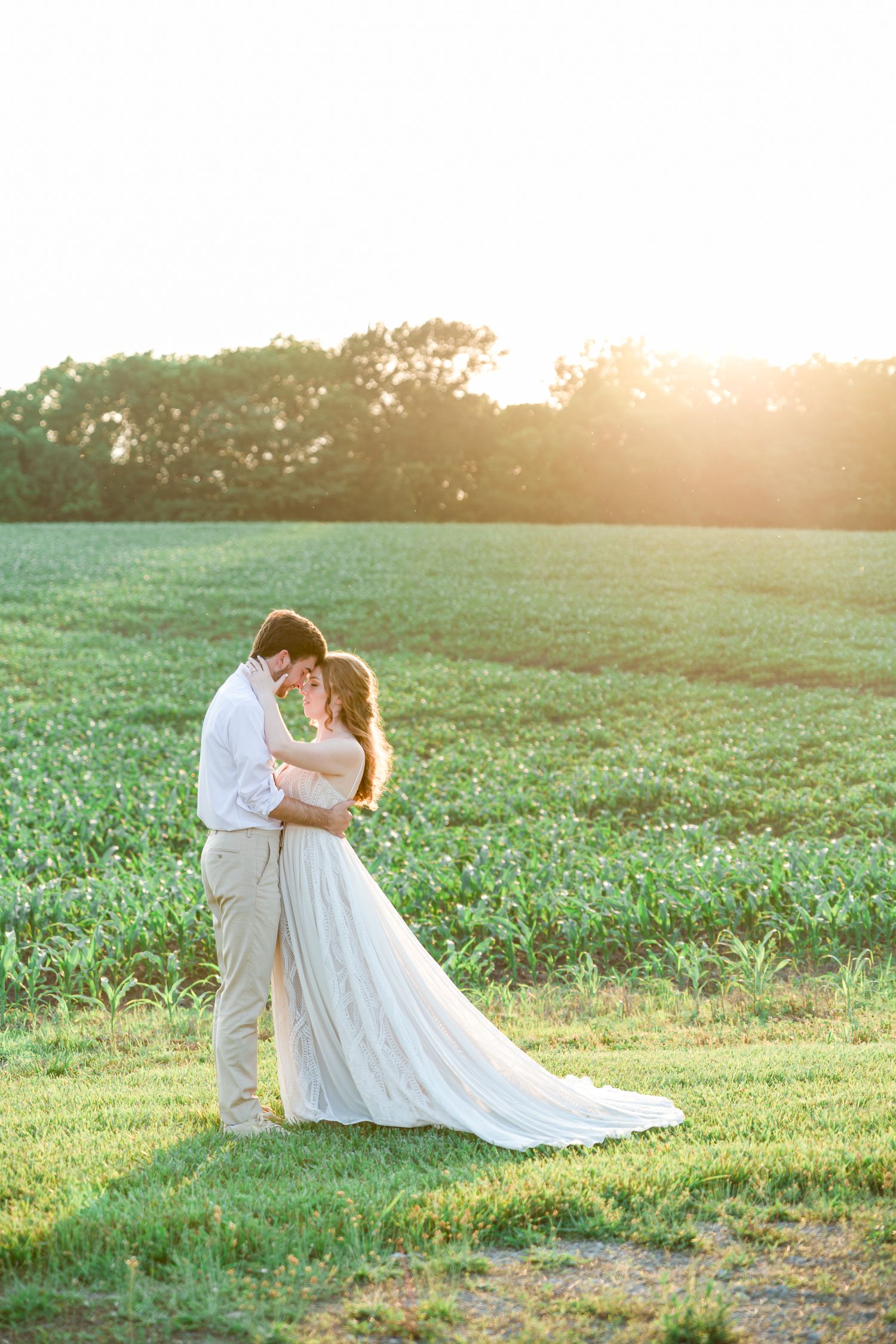 A romantic sunset wedding portrait in a green field with flowing white dress by Stephanie Coulter Photography