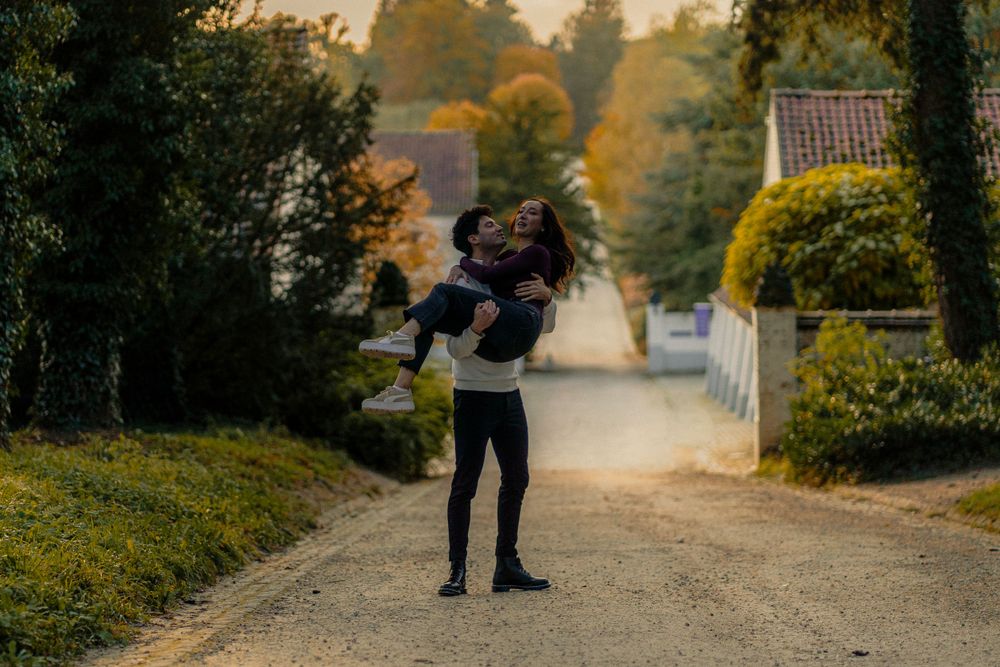 Le compagnon qui prend sa compagne dans ses bras en la soulèvent dans les airs dans une allée
