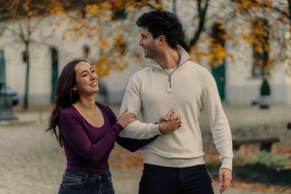 Un couple qui marche avec la compagne qui tient le bras de son compagnon