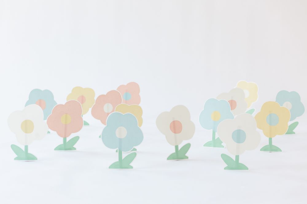 Paper flowers in pastel colors of blue, white, red and yellow against a white backdrop during a branding session in NYC