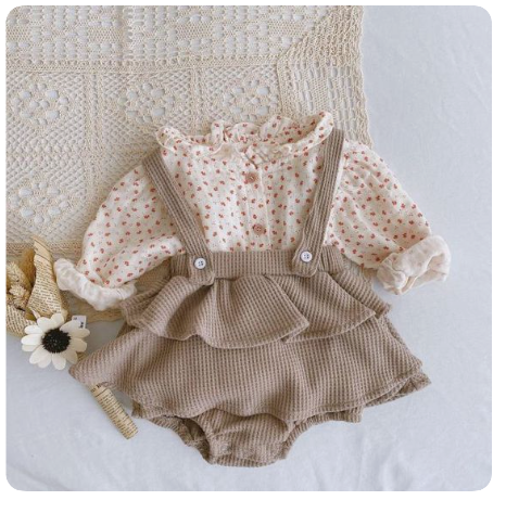 A vintage-style baby romper with floral print top and ribbed beige bottom with ruffled details.