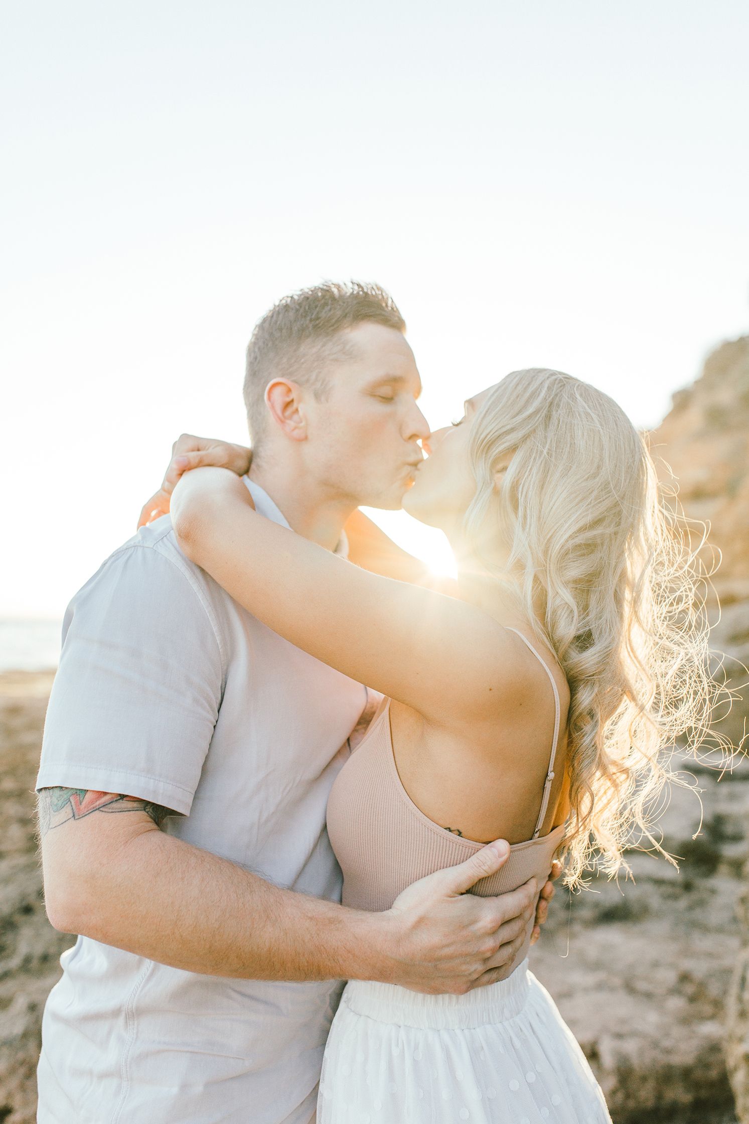 Romantic moment captured between two people at sunset by the beach.