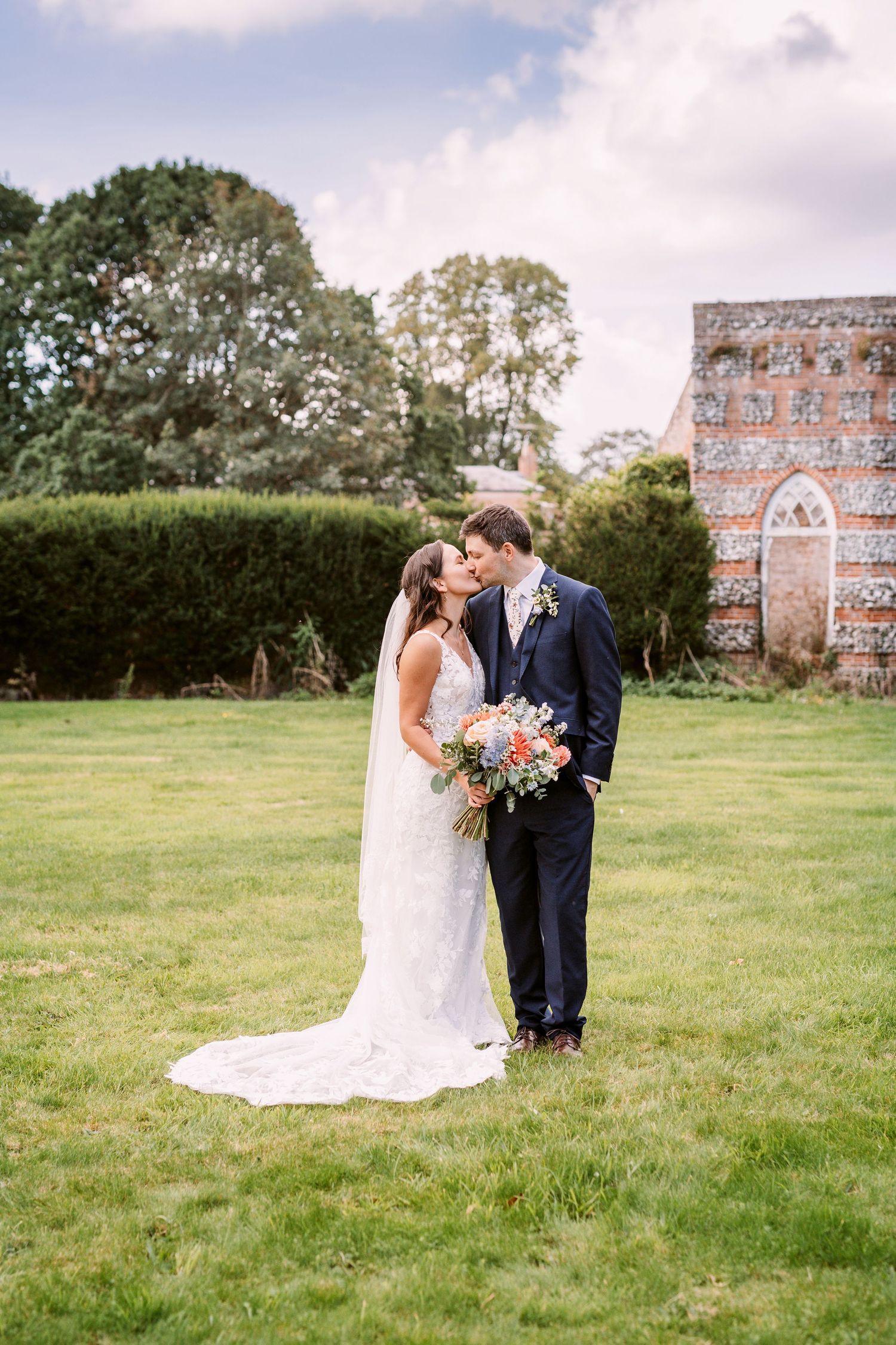 Beautiful Bride and groom kiss on their wedding day in the grounds of Mapledurham estate