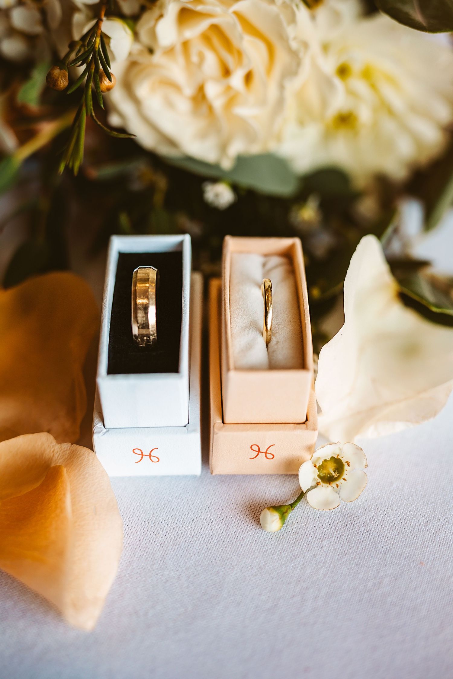 wedding bands in display boxes with bouquet