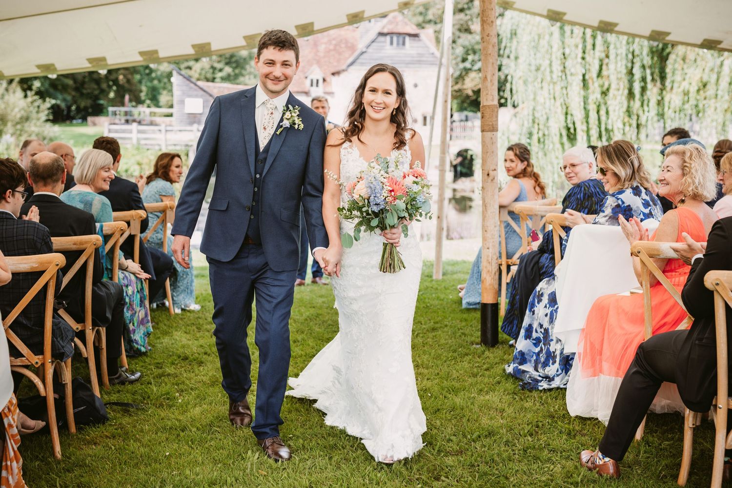 outdoor ceremony bride and groom walking up aisle newly married