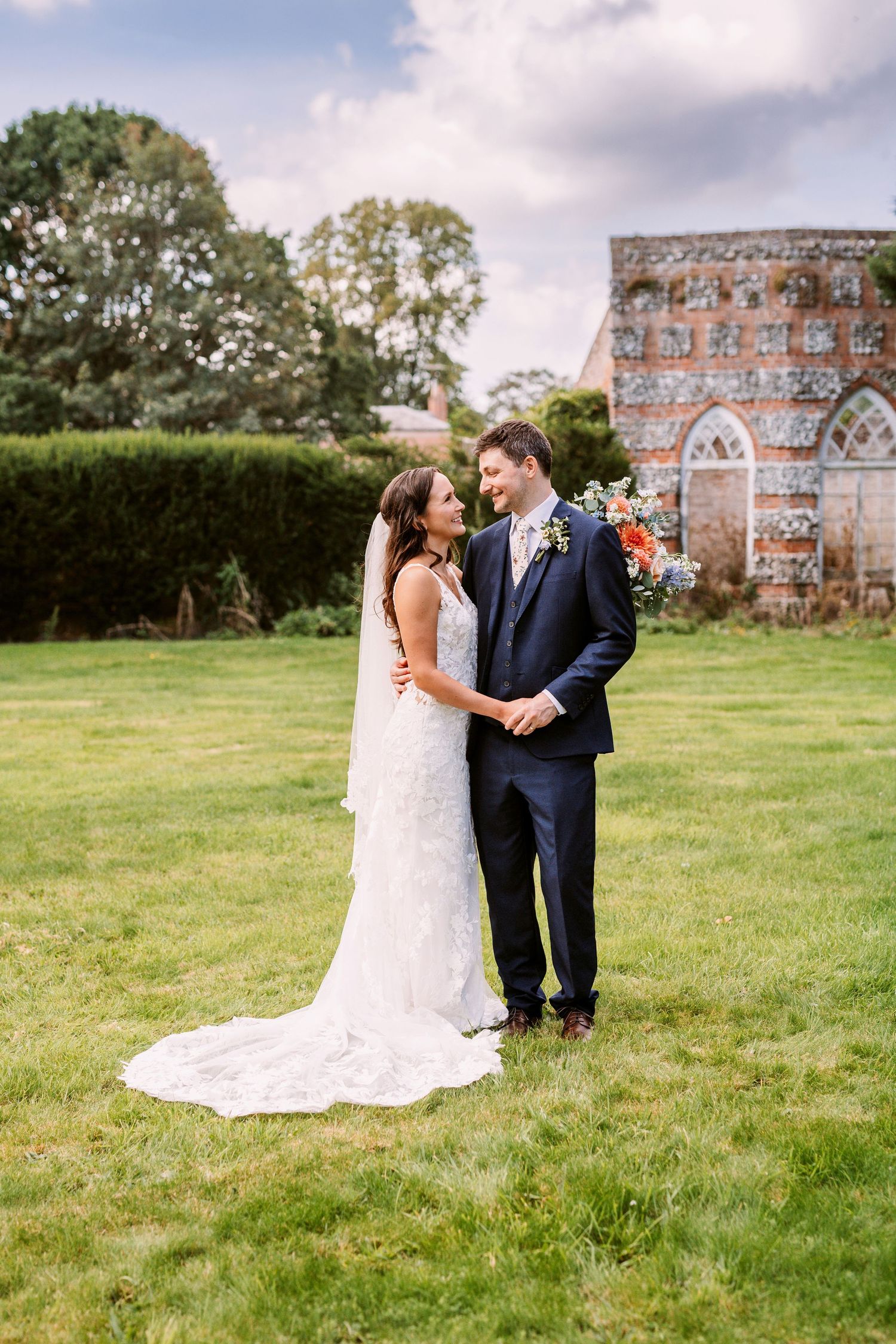 Beautiful Bride and groom holding hands in the grounds of Mapledurham estate
