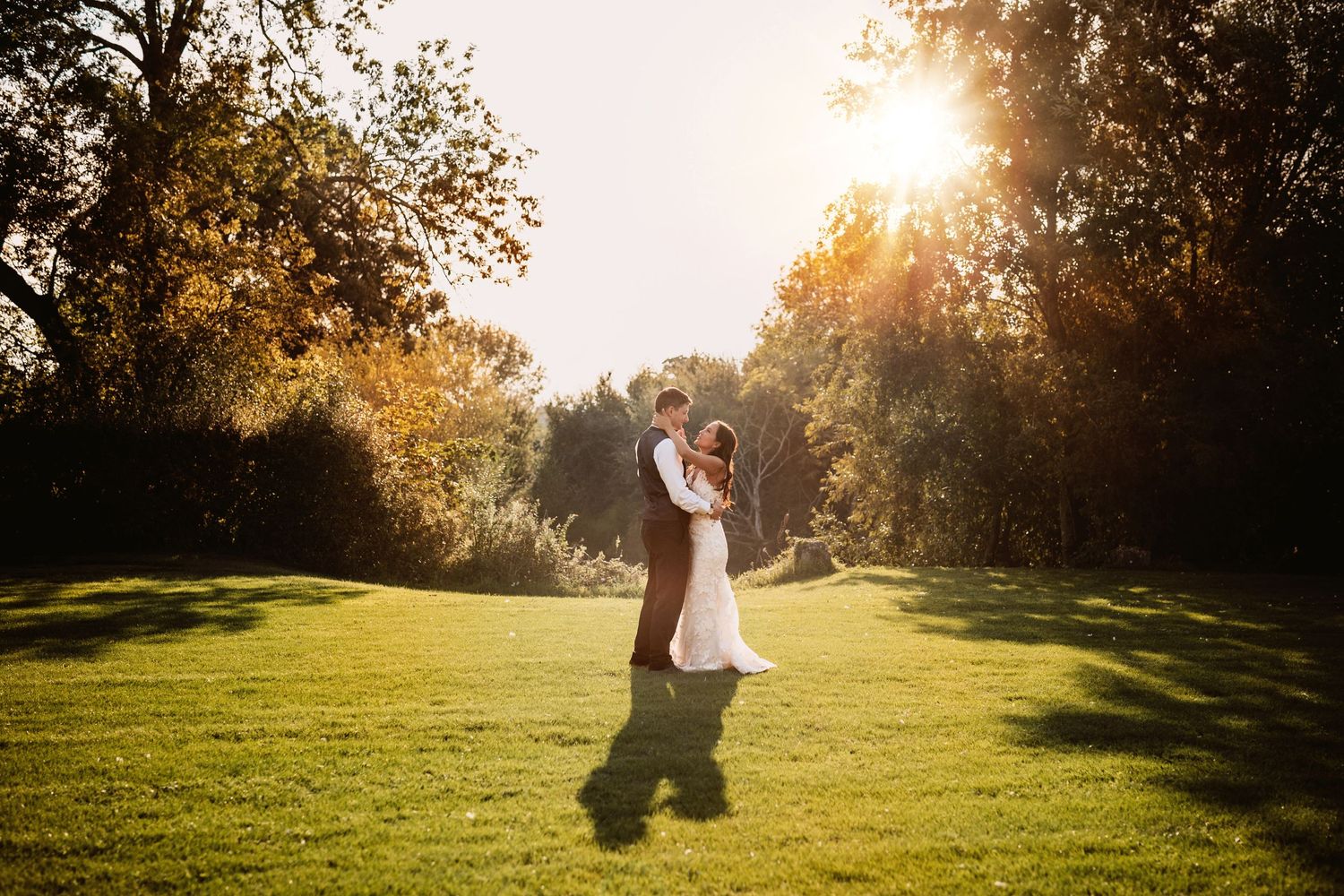 Dancing in golden sunset happy newly wed bride and groom at Mapledurham wedding venue