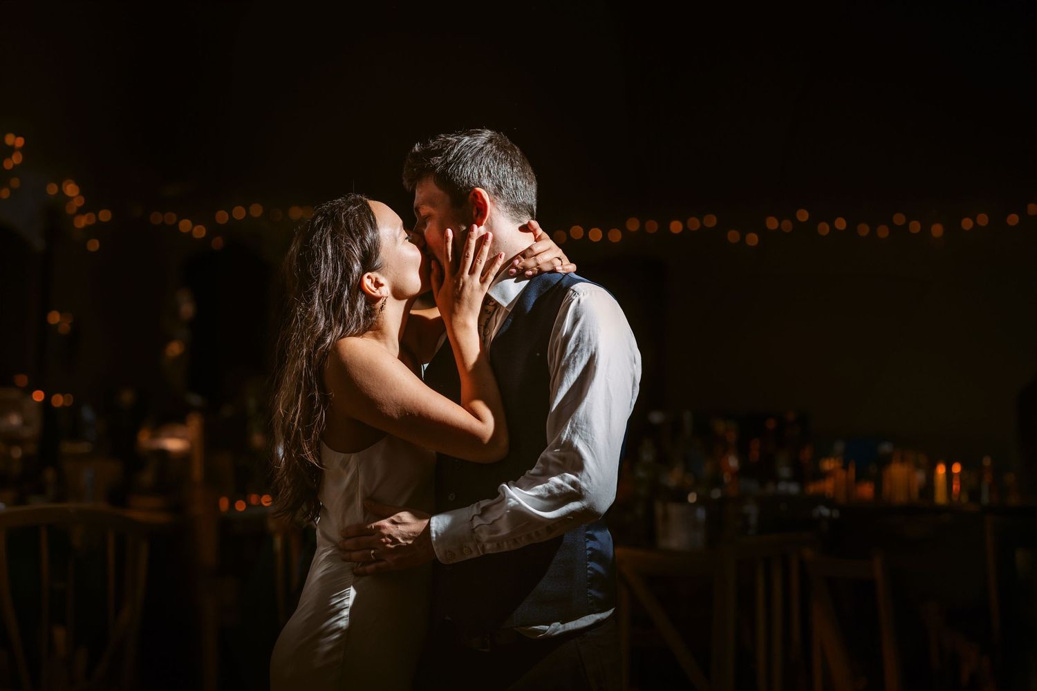 First dance newly wed bride and groom kissing on dance floor Mapledurham teepee