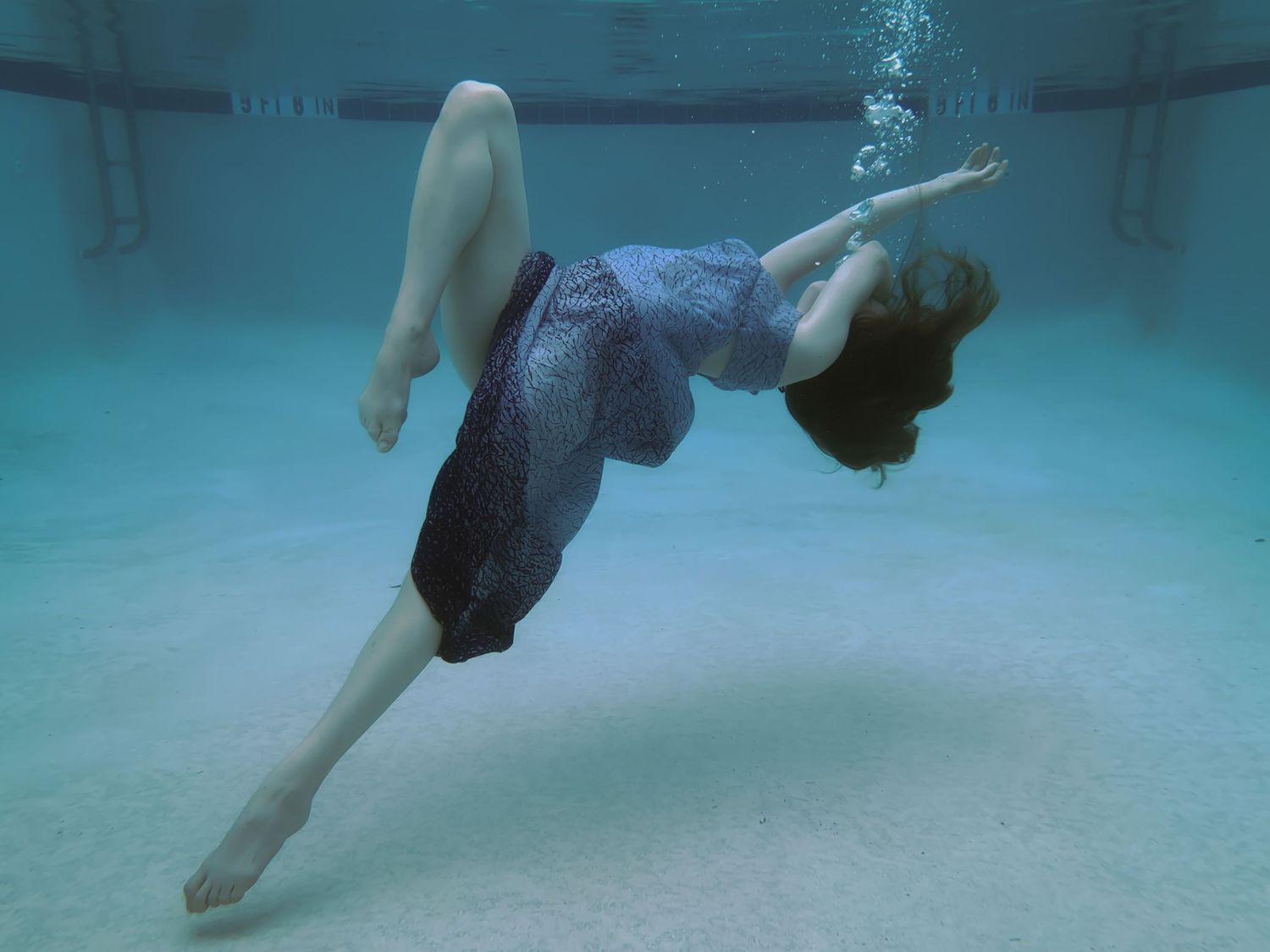A woman posing beneath the surface in a pool